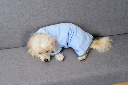 Dog lying down in the Harbor Blue drying robe after a bath